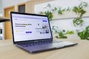 Close-up of a laptop with an open e-commerce website, surrounded by modern office decor.